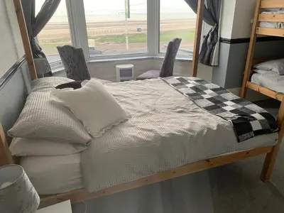 a bed in a room with two chairs and a window at St Albans Hotel in Blackpool
