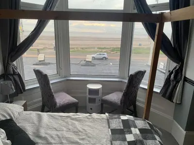 a bedroom with two chairs and a bed and a window at St Albans Hotel in Blackpool