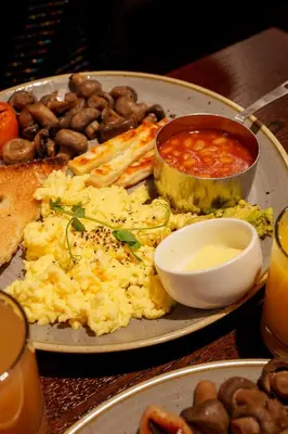 a plate of food with eggs and beans on a table at Miller & Carter Aughton by Innkeeper's Collection in Ormskirk