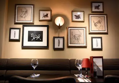 a room with a couch and framed pictures on the wall at Miller & Carter Aughton by Innkeeper's Collection in Ormskirk