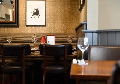 a restaurant with a table with chairs and a picture of a deer at Miller & Carter Aughton by Innkeeper's Collection in Ormskirk