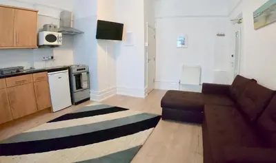 a kitchen with a couch and a stove top oven at Empress Select Holiday Flats in Blackpool