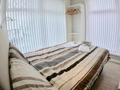 a bed sitting in a room with a large window at Empress Select Holiday Flats in Blackpool