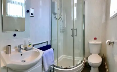 a bathroom with a shower and a sink and a toilet at Empress Select Holiday Flats in Blackpool