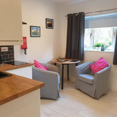 a kitchen with two chairs and a table and a window at Sweet Suites Residence in Lytham St Annes