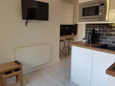 a kitchen with white cabinets and a microwave at Sweet Suites Residence in Lytham St Annes