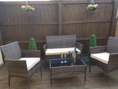 a patio with wicker chairs and a table on a deck at Sweet Suites Residence in Lytham St Annes