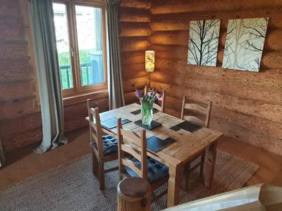 a wooden table with chairs and a vase of flowers on it at Newland Valley Log Cabins in Ulverston