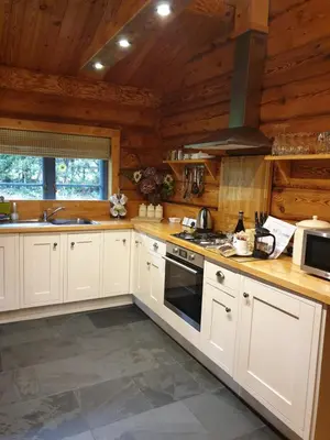 a kitchen with white cabinets and a stove top oven at Newland Valley Log Cabins in Ulverston