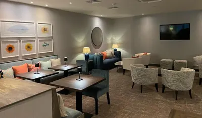 a waiting room with tables and chairs and a couch at Wrightington Hotel, Health Club & Spa in Wigan