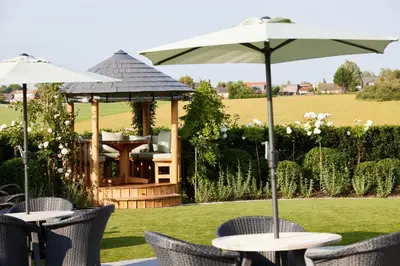 a gazebo with chairs and tables with an umbrella at Wrightington Hotel, Health Club & Spa in Wigan