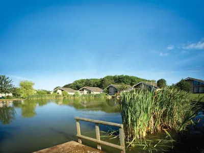 a body of water with houses in the background at The Motel, Ribby Hall Village in Wrea Green