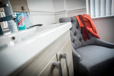 a chair with an orange towel sitting next to a counter at West Point House in Barrow in Furness