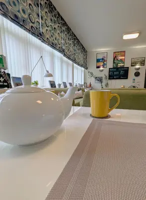 a tea pot sitting on a table in a living room at West Point House in Barrow in Furness