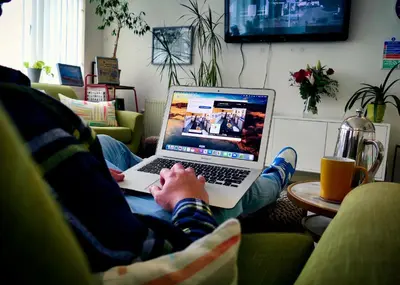a person sitting on a couch using a laptop computer at West Point House in Barrow in Furness