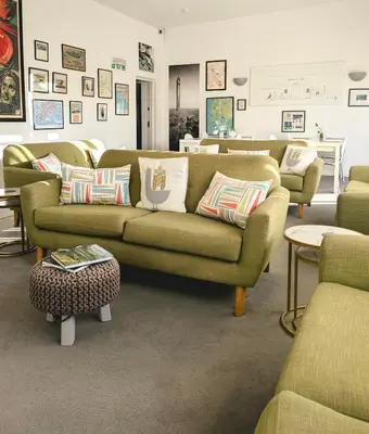 a living room with a green couch and chairs at West Point House in Barrow in Furness