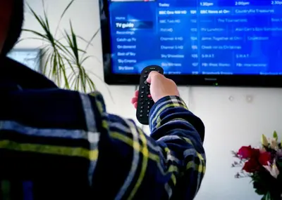 a person holding a remote control in front of a computer monitor at West Point House in Barrow in Furness