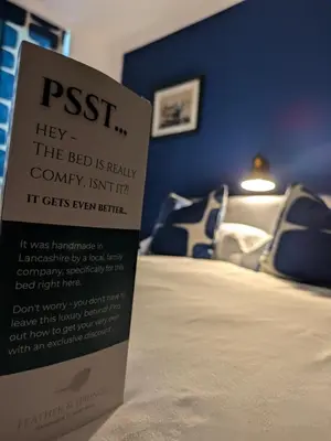 a sign next to a bed in a room at West Point House in Barrow in Furness