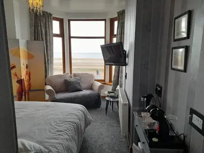 a bedroom with a bed and a couch and a television at The Fame in Blackpool