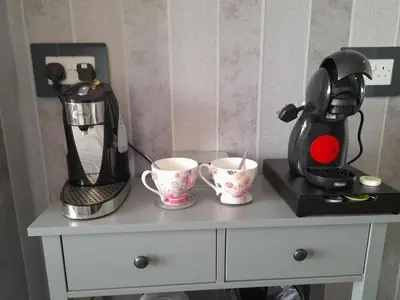 a coffee maker and two cups on a dresser at The Fame in Blackpool