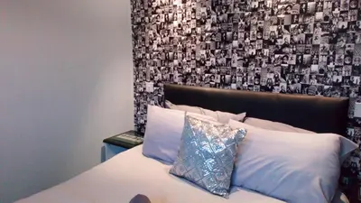 a bedroom with a bed with a wall with pictures at The Fame in Blackpool