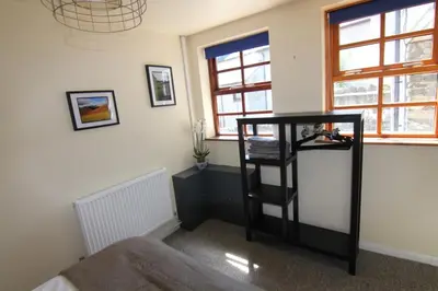 a room with a black shelf in a room with windows at 2 leather lane in Ulverston