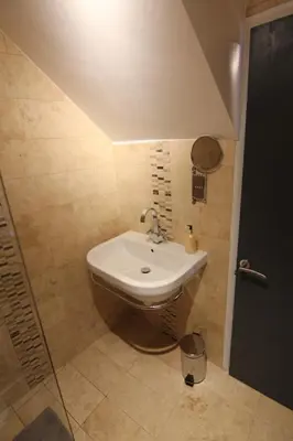 a bathroom with a white sink and a shower at 2 leather lane in Ulverston