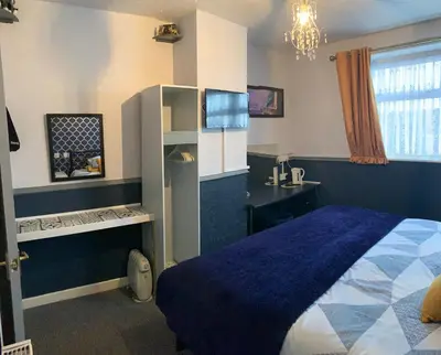 a bedroom with a blue bed and a desk at Hornby Villa B&B Couples & Families Only- Quiet Central Location- Near To Winter Gardens in Blackpool