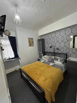 a bedroom with a bed and a chandelier at Hornby Villa B&B Couples & Families Only- Quiet Central Location- Near To Winter Gardens in Blackpool