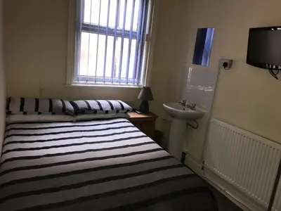 a small bedroom with a bed and a sink at Beach View Holiday Flats in Blackpool