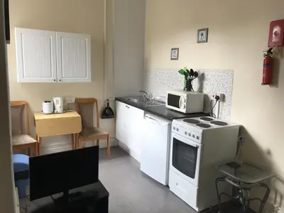 a kitchen with a white stove and a microwave at Beach View Holiday Flats in Blackpool