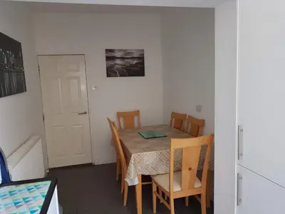a dining room with a table and chairs and a door at Central Location Preston 2 in Preston