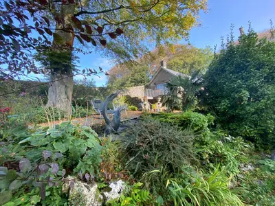 a garden with a statue in front of a house at The Stables, Ulverston in Ulverston