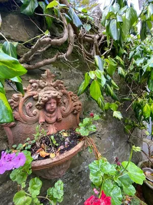 a stone planter with flowers in a garden at The Stables, Ulverston in Ulverston