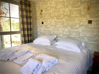 a bedroom with a bed with towels on it at The Stables, Ulverston in Ulverston