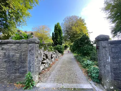 a stone wall next to a brick road at The Stables, Ulverston in Ulverston