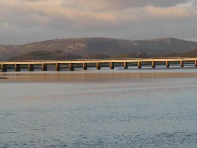 a bridge over the water with mountains in the background at Kentwood Guest House in Arnside