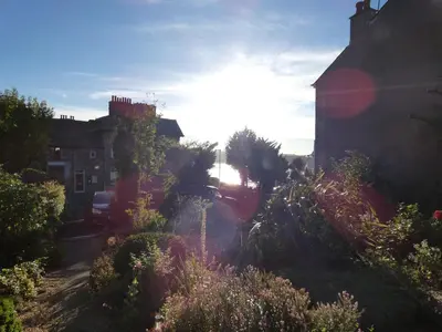 a view of a garden with flowers and a building at Kentwood Guest House in Arnside