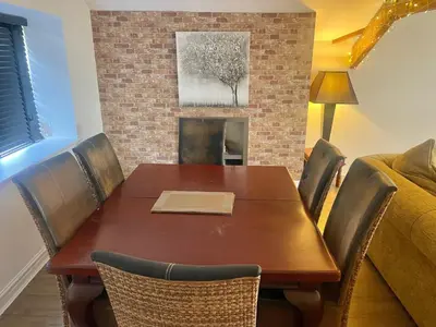 a dining room table with chairs and a fireplace at Beach House - Penthouse 3 Bed Apartment in Southport
