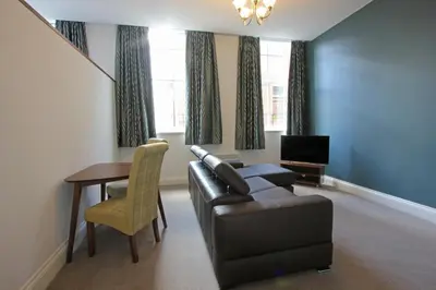 a living room with a leather couch and a table at The Castle Collection - 3 Union Court in Liverpool