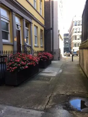 a street with some flowers in pots next to a building at The Castle Collection - 3 Union Court in Liverpool