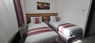 two beds in a hotel room withskirts at Escape Hotel in Barrow in Furness
