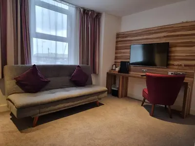 a living room with a couch and a flat screen tv at Escape Hotel in Barrow in Furness