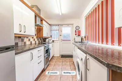 a kitchen with white cabinets and marble counter tops at Wigan Work-Ready 3BR House Sleeps 6 Guests in Wigan