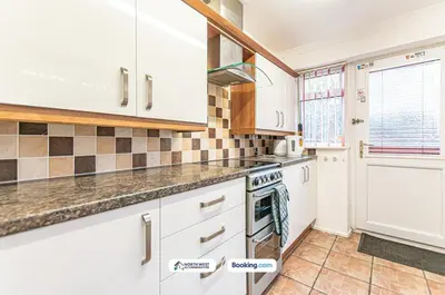 a kitchen with white cabinets and a stove at Wigan Work-Ready 3BR House Sleeps 6 Guests in Wigan