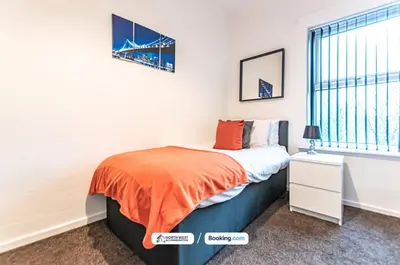 a bedroom with a bed with an orange blanket at Wigan Work-Ready 3BR House Sleeps 6 Guests in Wigan