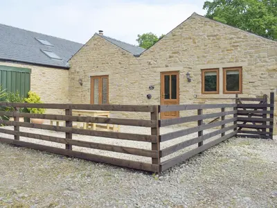 a wooden fence in front of a house at Woodpecker Cottage - Ukc3412 in Bolton by Bowland