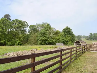 a fence with a pile of rocks next to a field at Woodpecker Cottage - Ukc3412 in Bolton by Bowland