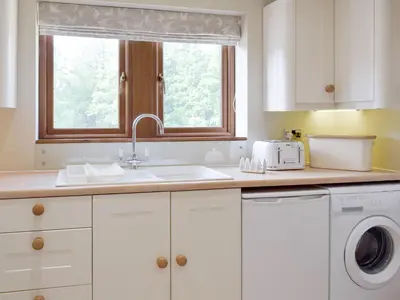 a white kitchen with a sink and a window at Woodpecker Cottage - Ukc3412 in Bolton by Bowland