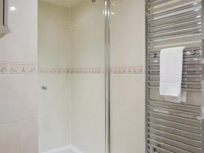 a bathroom with a shower with a glass door at Woodpecker Cottage - Ukc3412 in Bolton by Bowland